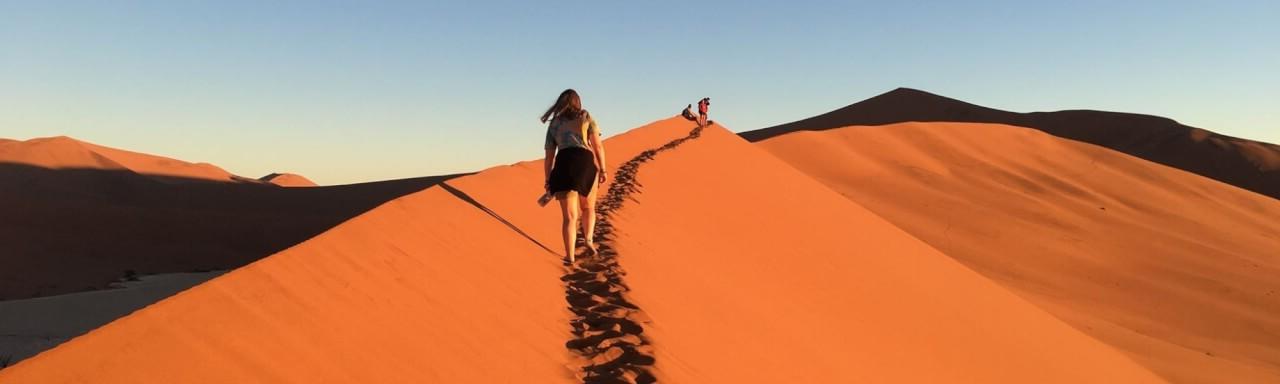 A GVSU student walks along a sand dune in Namibia Africa.